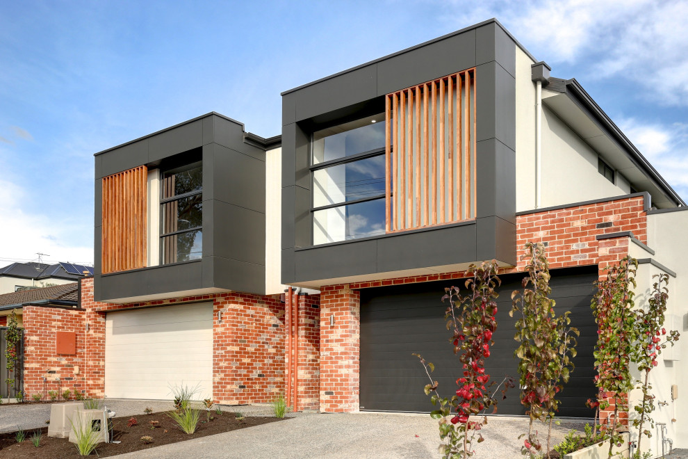 Foto della facciata di una casa a schiera moderna a due piani con copertura in metallo o lamiera e tetto grigio