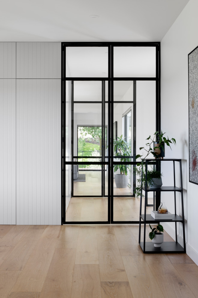 Großer Moderner Flur mit weißer Wandfarbe, hellem Holzboden, braunem Boden und Holzdielenwänden in Melbourne