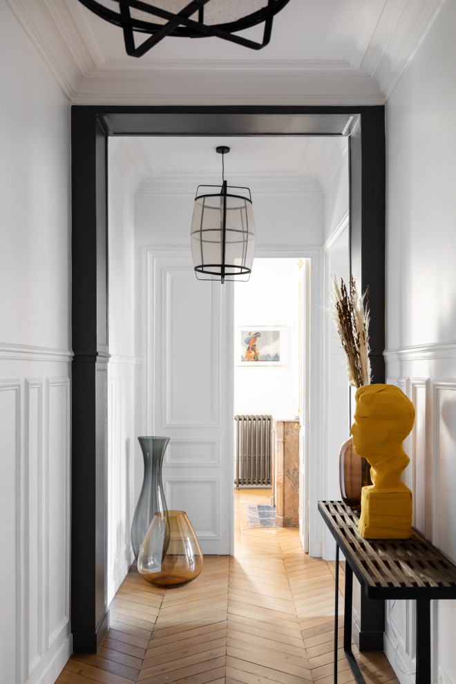 Inspiration for a large contemporary hallway in Paris with white walls, light hardwood floors, brown floor and wood walls.