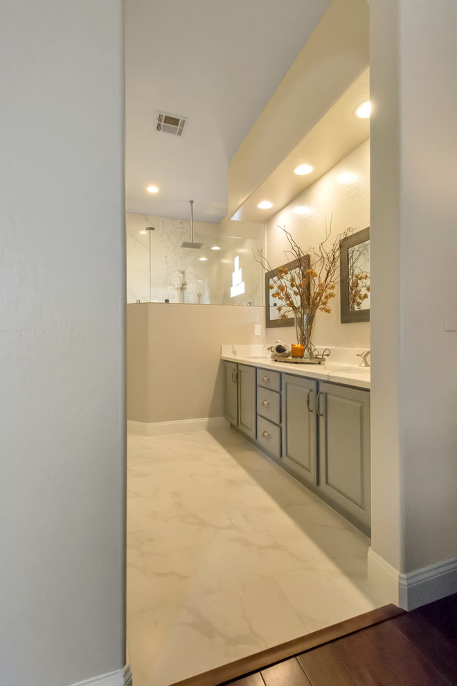 Inspiration for a large transitional master bathroom in Phoenix with white tile, engineered quartz benchtops, an open shower, raised-panel cabinets, grey cabinets, an open shower, marble, white walls, marble floors, an undermount sink and white floor.
