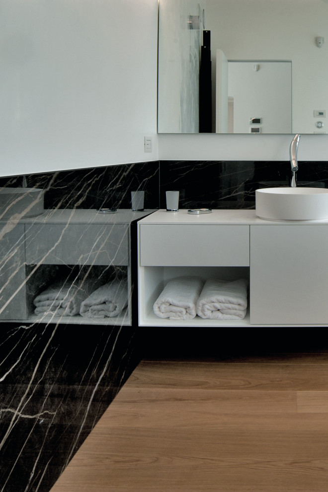 Photo of a large modern master bathroom in Los Angeles with flat-panel cabinets, white cabinets, black tile, porcelain tile, white walls, plywood floors, a vessel sink, solid surface benchtops, beige floor, white benchtops, a single vanity and a floating vanity.