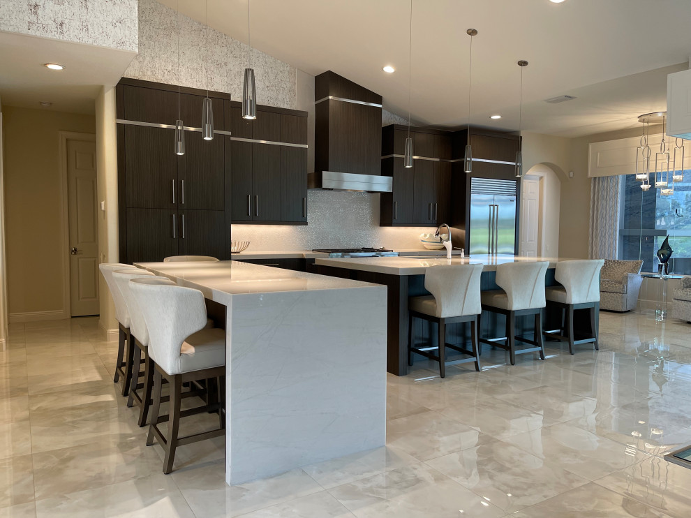This is an example of a mid-sized transitional kitchen in Miami with an undermount sink, flat-panel cabinets, dark wood cabinets, marble benchtops, white splashback, stainless steel appliances, marble floors, multiple islands, beige benchtop and vaulted.