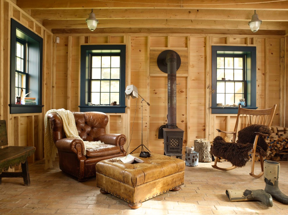 Design ideas for a country enclosed living room in New York with brick floors, a wood stove and beige floor.