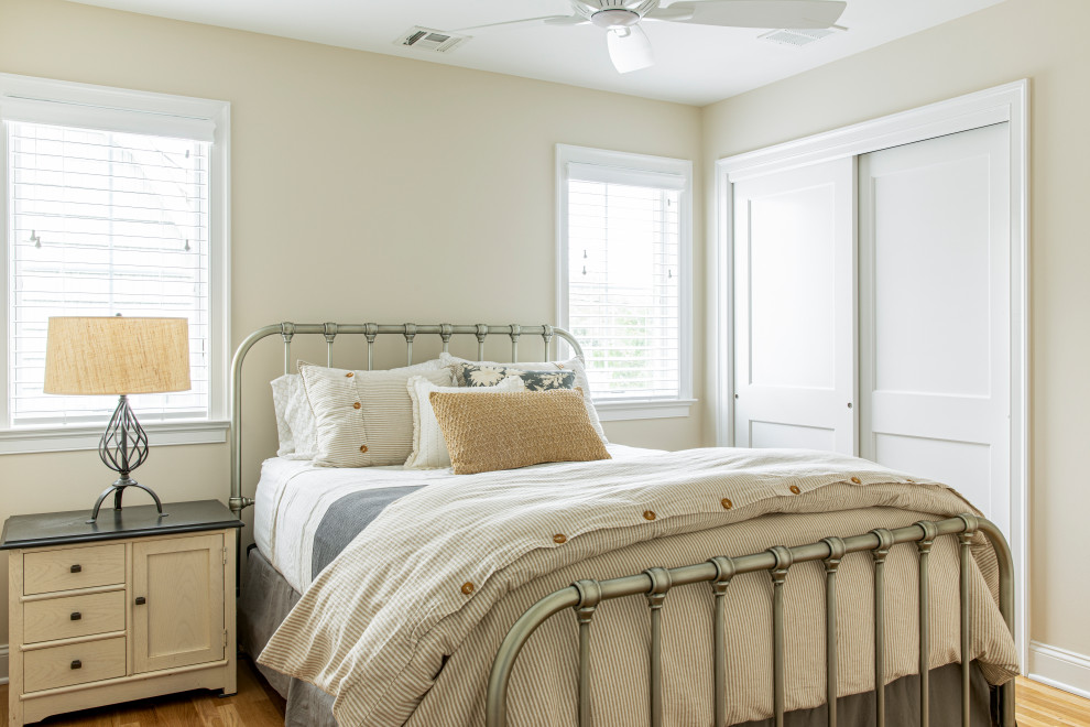 Inspiration for a beach style bedroom in New York with beige walls and light hardwood floors.