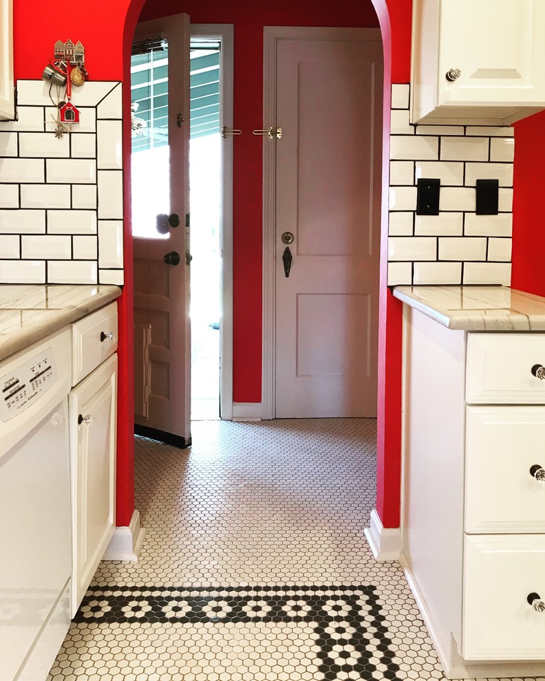 Photo of a mid-sized eclectic galley separate kitchen in Kansas City with raised-panel cabinets, white cabinets, marble benchtops, white splashback, subway tile splashback, white appliances, porcelain floors, no island, yellow floor and white benchtop.
