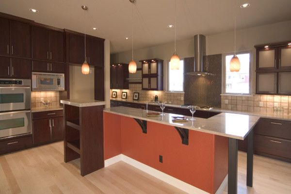 Kitchen photo in Denver with flat-panel cabinets, dark wood cabinets, granite countertops, stainless steel appliances and an island