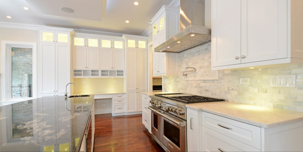 Kitchen photo in Chicago with granite countertops, white backsplash, stainless steel appliances and an island