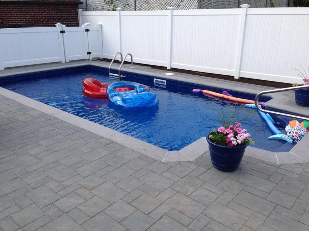Inspiration for a large arts and crafts backyard custom-shaped pool in New York with natural stone pavers.