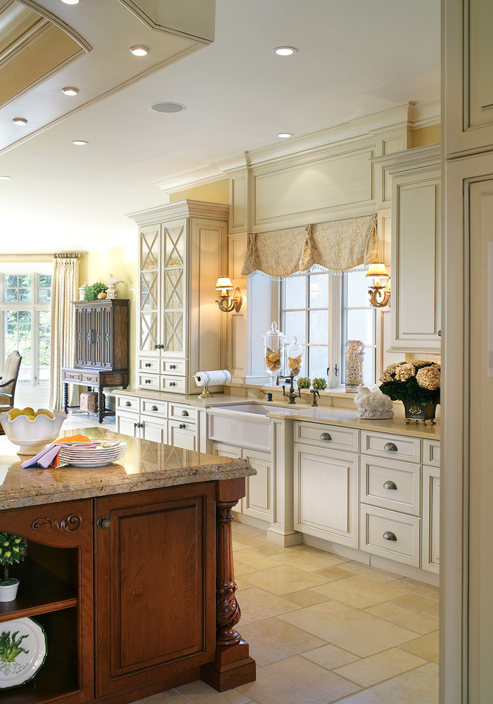 Inspiration for a large traditional galley eat-in kitchen in New York with a farmhouse sink, raised-panel cabinets, granite benchtops, panelled appliances and limestone floors.