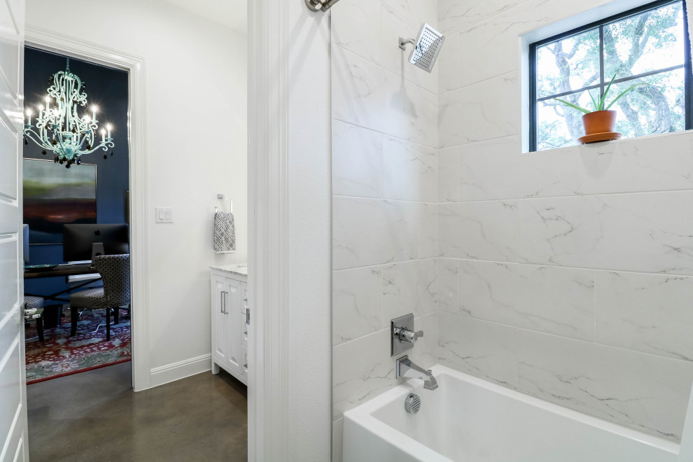 Inspiration för mellanstora moderna vitt badrum, med möbel-liknande, vita skåp, ett badkar i en alkov, en dusch/badkar-kombination, en toalettstol med hel cisternkåpa, vit kakel, marmorkakel, vita väggar, betonggolv, ett undermonterad handfat, marmorbänkskiva, grått golv och dusch med duschdraperi
