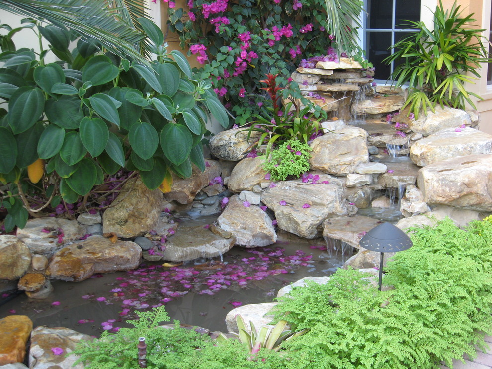 Immagine di un giardino tropicale davanti casa con fontane