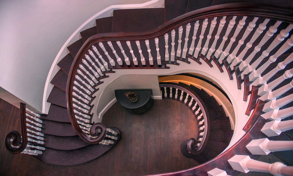 Large transitional wood spiral staircase in DC Metro with wood risers and wood railing.
