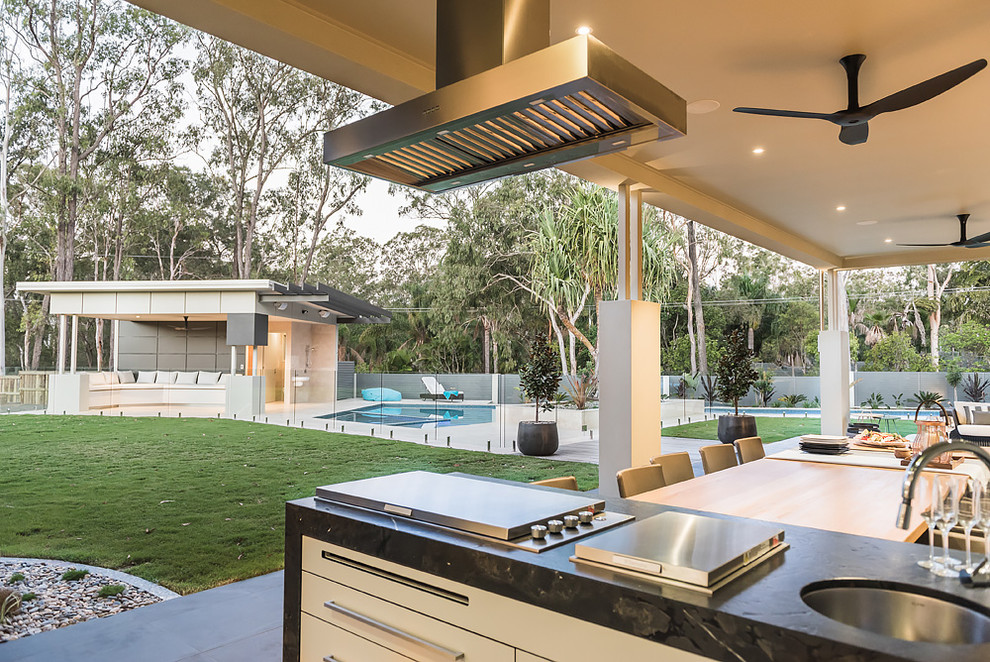 Design ideas for an expansive contemporary backyard patio in Brisbane with an outdoor kitchen, decomposed granite and a roof extension.