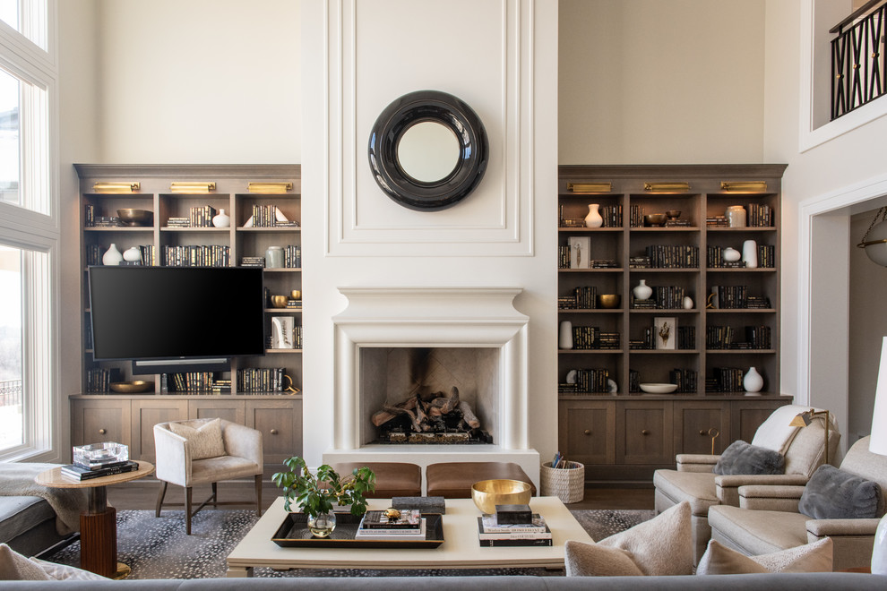 Photo of a transitional family room in Salt Lake City with beige walls, dark hardwood floors, a standard fireplace, a wall-mounted tv and brown floor.