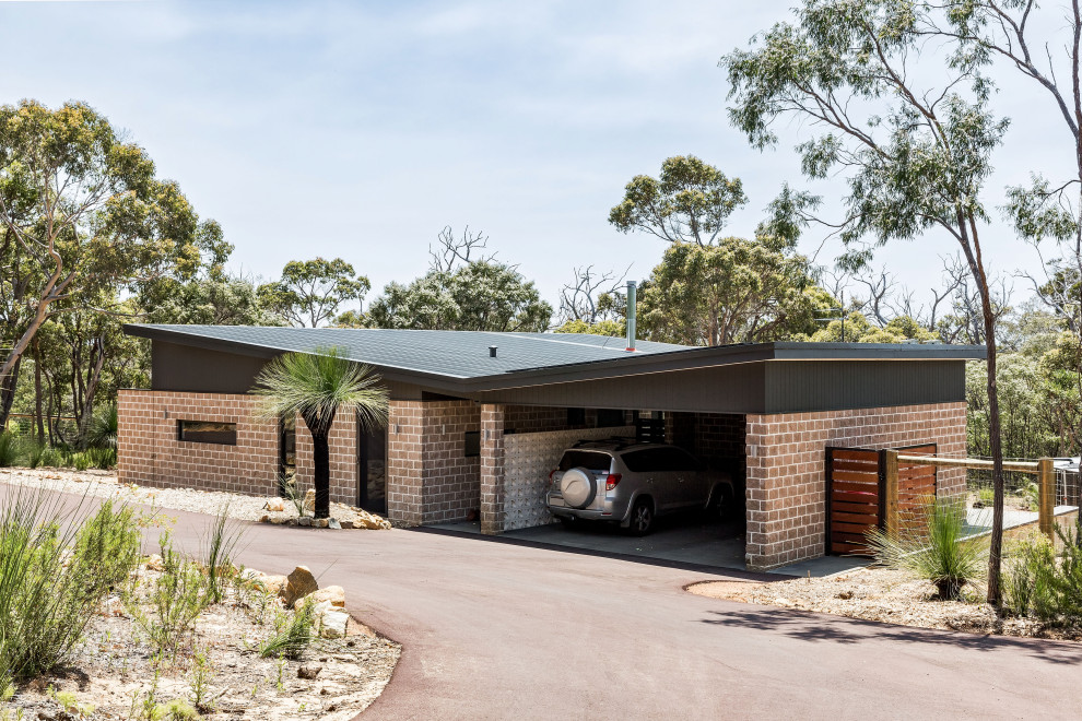 Photo of a small midcentury one-storey brick black house exterior in Perth with a butterfly roof, a metal roof and a black roof.
