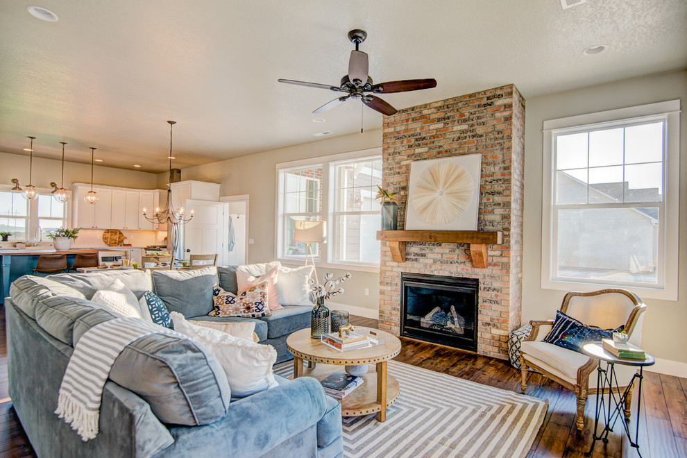 Design ideas for a mid-sized country open concept family room in Seattle with laminate floors, a standard fireplace and a brick fireplace surround.