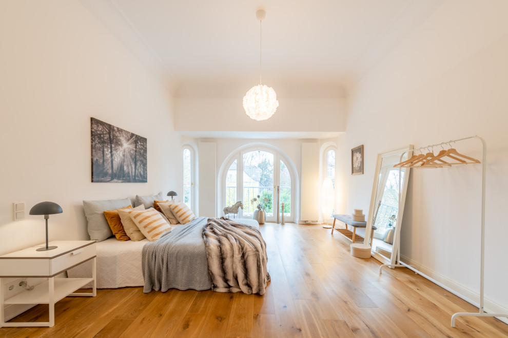 Modernes Schlafzimmer mit weißer Wandfarbe, braunem Holzboden und braunem Boden in Hamburg