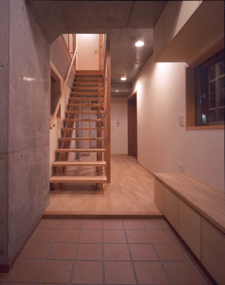 Foto på en mellanstor minimalistisk hall, med bruna väggar, klinkergolv i keramik, en dubbeldörr, mörk trädörr och orange golv