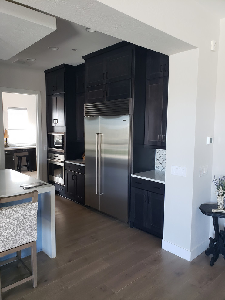 Example of a huge transitional porcelain tile eat-in kitchen design in Phoenix with an undermount sink, shaker cabinets, dark wood cabinets, quartz countertops, multicolored backsplash, mosaic tile backsplash, stainless steel appliances, an island and white countertops