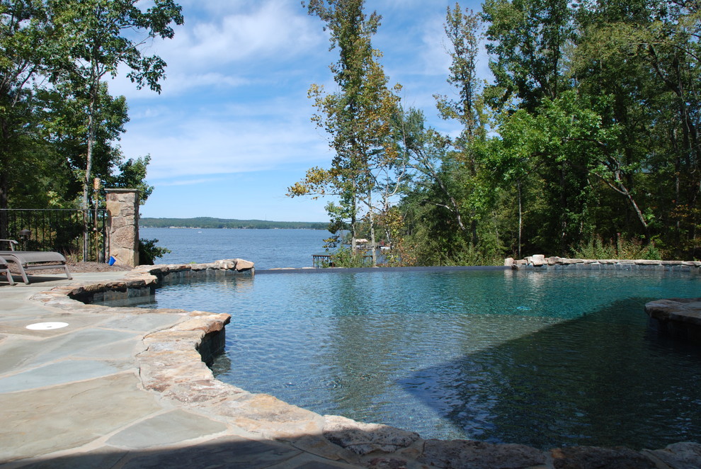 Example of a large mountain style backyard stone and custom-shaped infinity pool design in Charleston