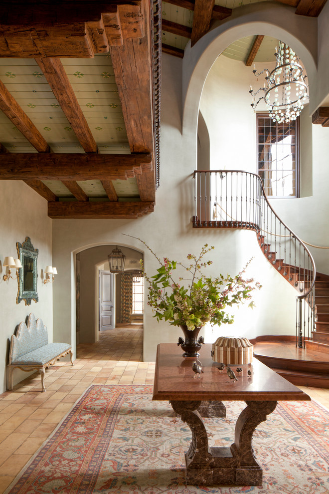 Design ideas for a large mediterranean foyer in Los Angeles with white walls and brick floors.