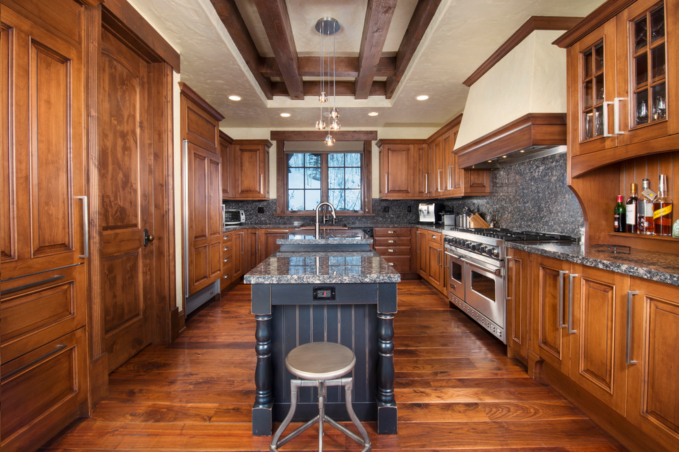 Mountain style u-shaped medium tone wood floor kitchen photo in Denver with raised-panel cabinets, medium tone wood cabinets, gray backsplash, stainless steel appliances and an island