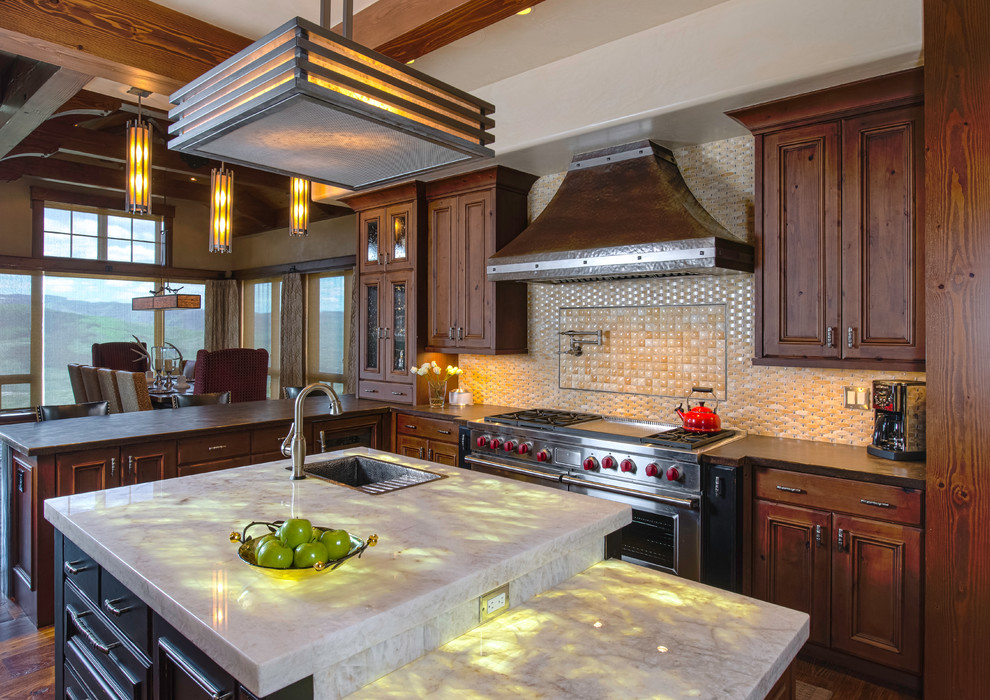 Large mountain style medium tone wood floor and brown floor eat-in kitchen photo with a drop-in sink, medium tone wood cabinets, onyx countertops, beige backsplash, recessed-panel cabinets and an island