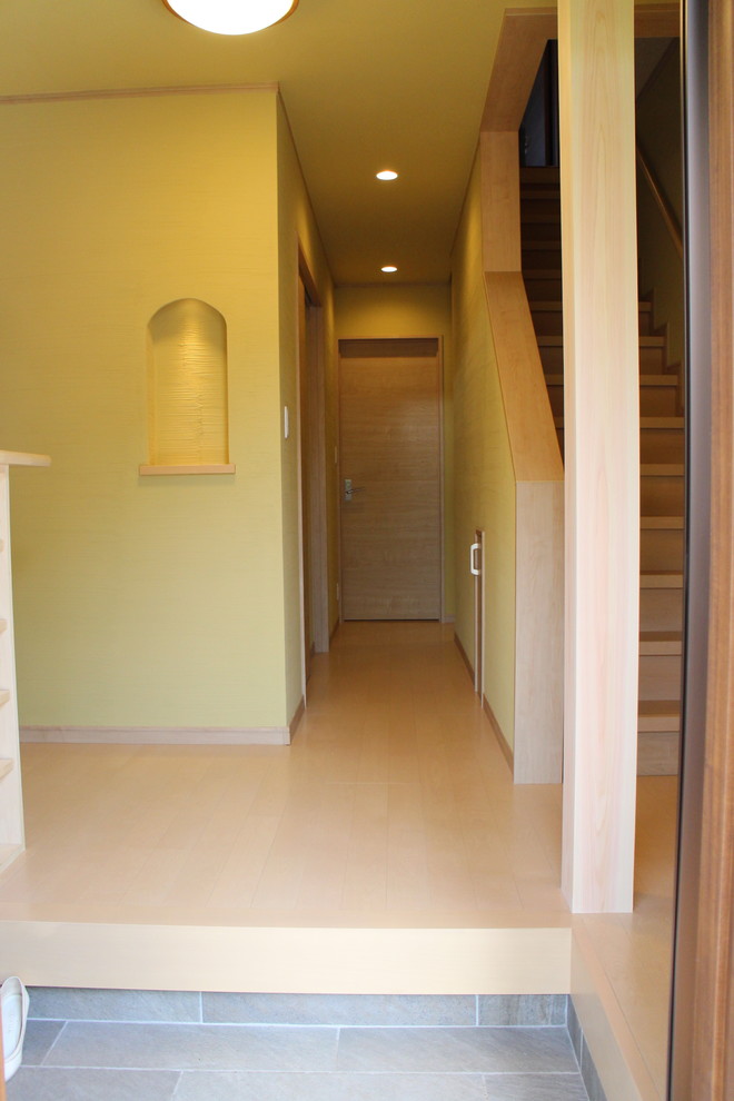 Design ideas for an asian entryway in Other with green walls, plywood floors and beige floor.