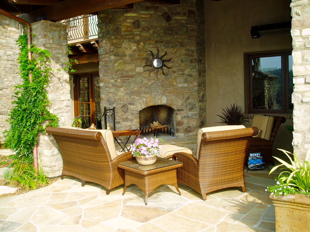 Mid-sized mediterranean backyard patio in San Diego with natural stone pavers and a roof extension.