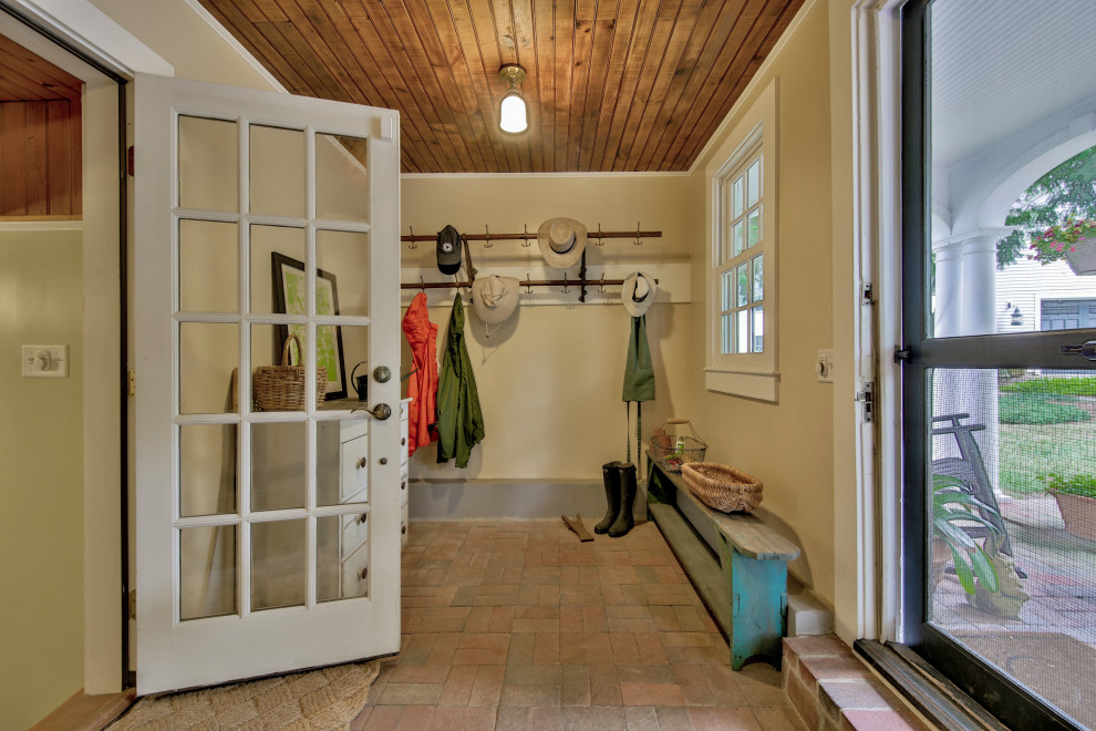 Photo of a mid-sized traditional mudroom in Boston with beige walls, brick floors, a dutch front door, a green front door, red floor and wood.