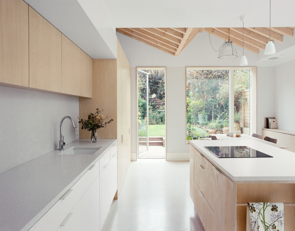 Inspiration for a mid-sized contemporary galley eat-in kitchen in London with an undermount sink, flat-panel cabinets, light wood cabinets, terrazzo benchtops, stainless steel appliances, with island and vaulted.