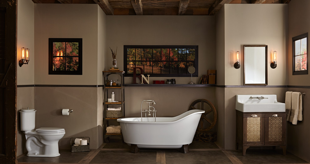 Photo of a mid-sized arts and crafts master bathroom in Chicago with furniture-like cabinets, dark wood cabinets, a freestanding tub, a one-piece toilet, brown walls, concrete floors, a trough sink and brown floor.