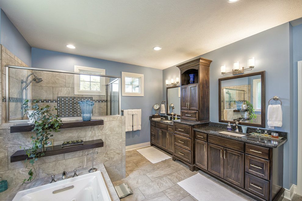 Inspiration for a large transitional master beige tile and porcelain tile porcelain tile and beige floor drop-in bathtub remodel with recessed-panel cabinets, dark wood cabinets, blue walls, an undermount sink and a hinged shower door
