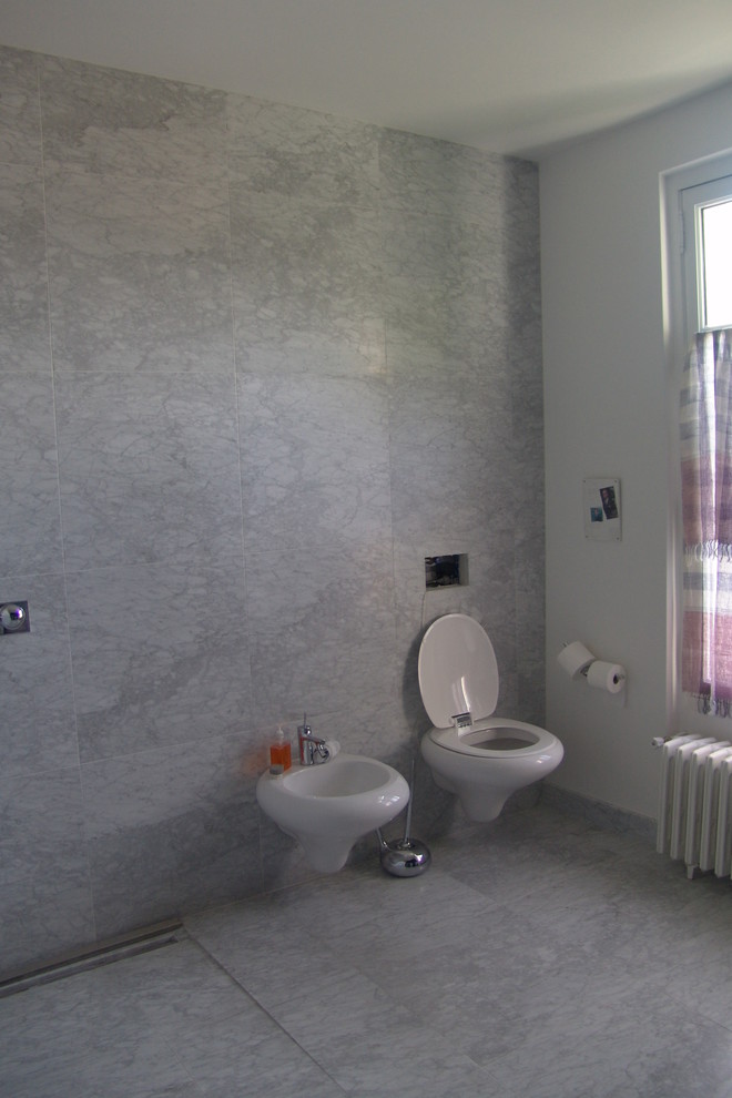 Inspiration for a large contemporary 3/4 bathroom in Marseille with a curbless shower, a wall-mount toilet, gray tile, stone slab, grey walls, marble floors and a wall-mount sink.