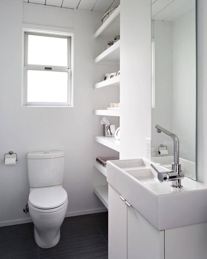 Photo of a small midcentury bathroom in San Francisco with a vessel sink, flat-panel cabinets, white cabinets, a two-piece toilet and white walls.