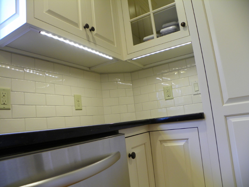 Eat-in kitchen - mid-sized transitional u-shaped light wood floor eat-in kitchen idea with an undermount sink, beaded inset cabinets, white cabinets, quartz countertops, white backsplash, subway tile backsplash, stainless steel appliances and no island