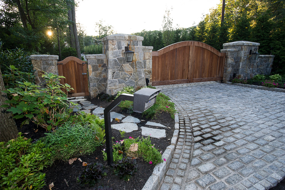 Country front yard driveway in New York with a garden path and concrete pavers.