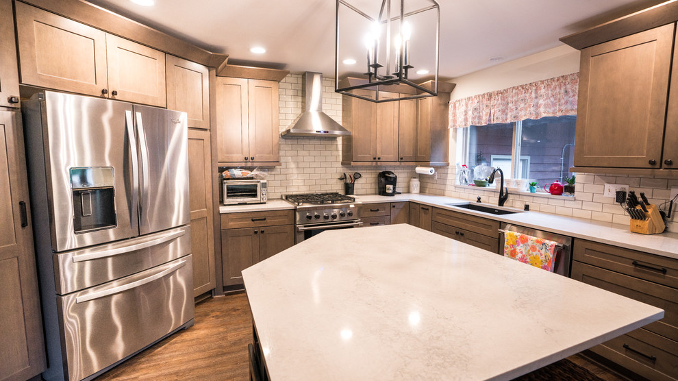 Open concept kitchen - large transitional l-shaped vinyl floor and brown floor open concept kitchen idea in Seattle with an undermount sink, recessed-panel cabinets, medium tone wood cabinets, quartz countertops, subway tile backsplash, stainless steel appliances, an island, white countertops and white backsplash