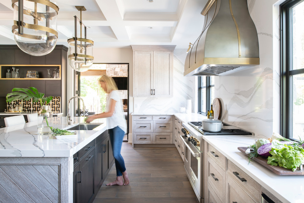 Inspiration for a mid-sized country l-shaped kitchen in Minneapolis with a single-bowl sink, quartz benchtops, stainless steel appliances, brown floor, shaker cabinets, light wood cabinets, white splashback, stone slab splashback, dark hardwood floors, with island and white benchtop.