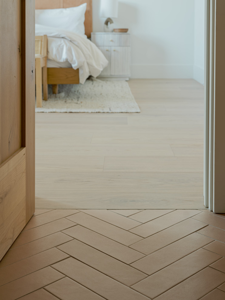 Photo of a bedroom in Phoenix with ceramic floors and brown floor.
