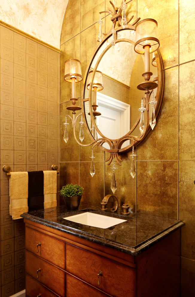 This is an example of a traditional powder room in New York with an undermount sink, furniture-like cabinets, medium wood cabinets, granite benchtops, a one-piece toilet, beige tile, beige walls and metal tile.