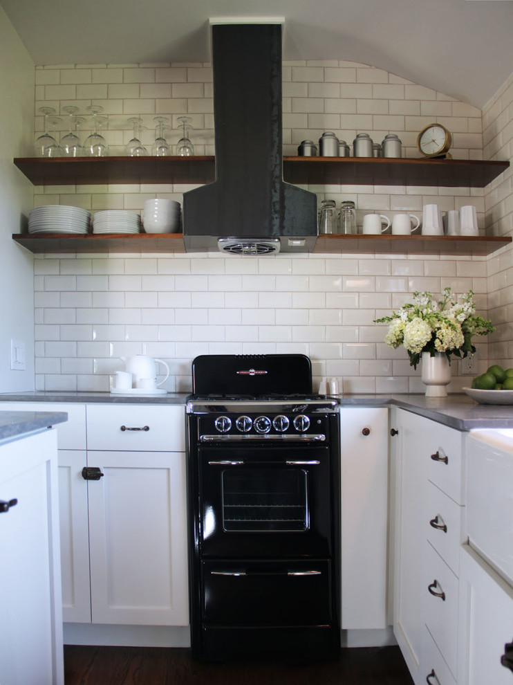 Traditional kitchen in Los Angeles with a farmhouse sink, open cabinets, white cabinets, white splashback, subway tile splashback, black appliances and limestone benchtops.