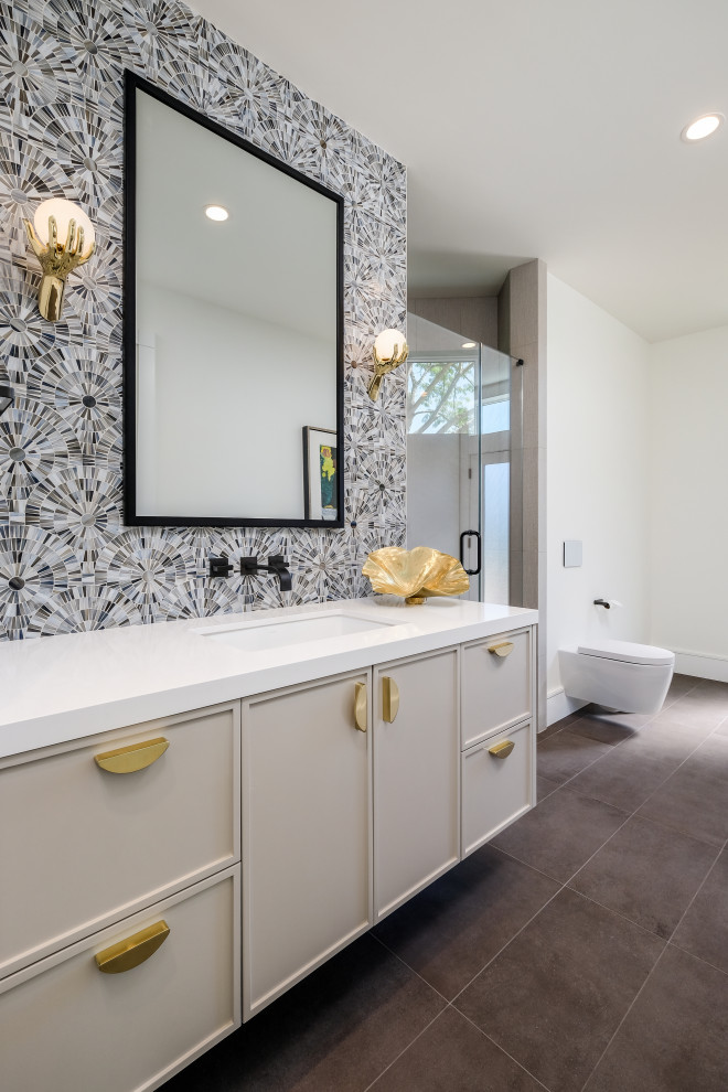 Inspiration for a transitional 3/4 bathroom in San Francisco with recessed-panel cabinets, grey cabinets, an alcove shower, a wall-mount toilet, multi-coloured tile, white walls, an undermount sink, brown floor, a hinged shower door, white benchtops, a single vanity and a floating vanity.