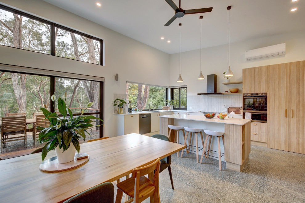 Example of a trendy concrete floor and gray floor kitchen/dining room combo design in Adelaide with white walls