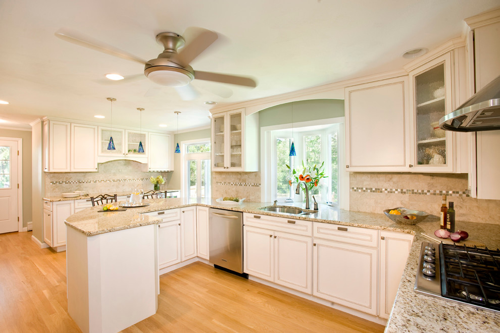 Mid-sized transitional u-shaped light wood floor eat-in kitchen photo in Boston with a double-bowl sink, recessed-panel cabinets, white cabinets, granite countertops, multicolored backsplash, ceramic backsplash, stainless steel appliances and a peninsula