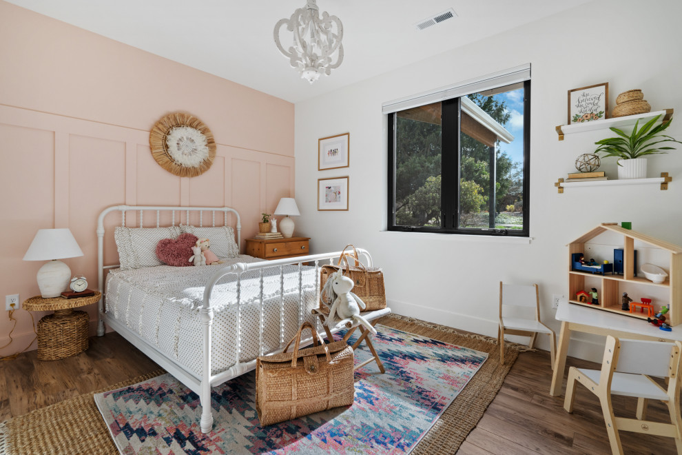 Foto di una cameretta per bambini country di medie dimensioni con pareti rosa, pavimento in laminato, pavimento bianco e pareti in legno