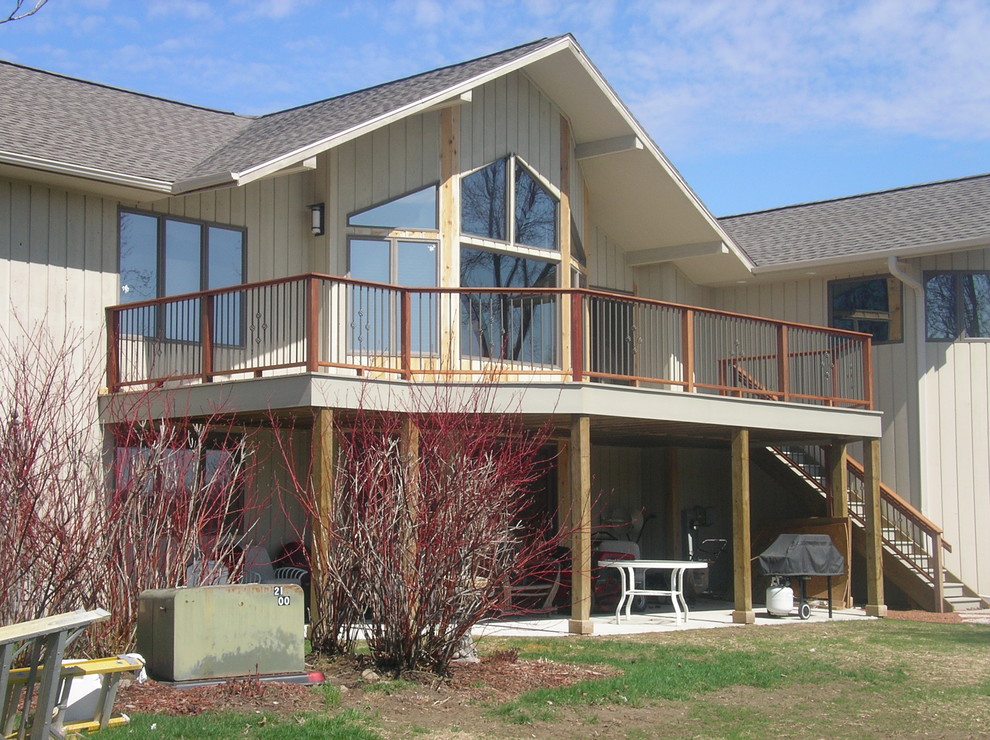 Example of a large backyard deck design with a roof extension