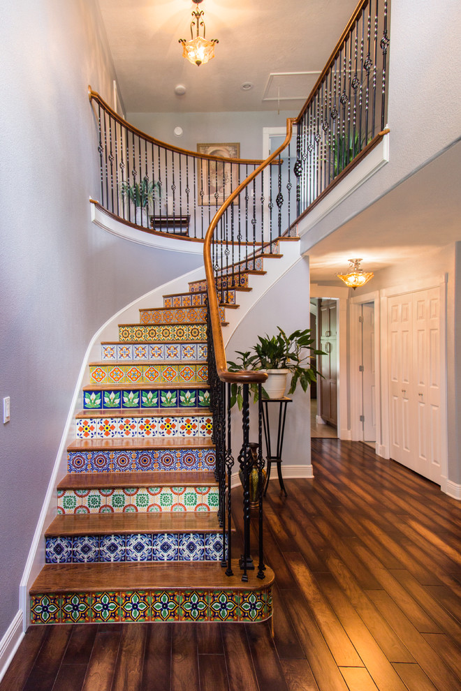 Photo of a large mediterranean wood curved staircase in Tampa with tile risers.