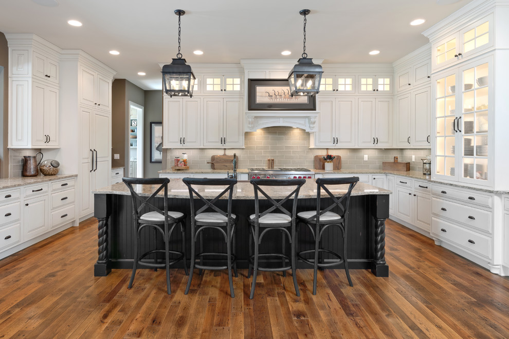 Design ideas for a large traditional kitchen in Cincinnati with granite benchtops, grey splashback, subway tile splashback, stainless steel appliances, with island, raised-panel cabinets, medium hardwood floors and grey benchtop.
