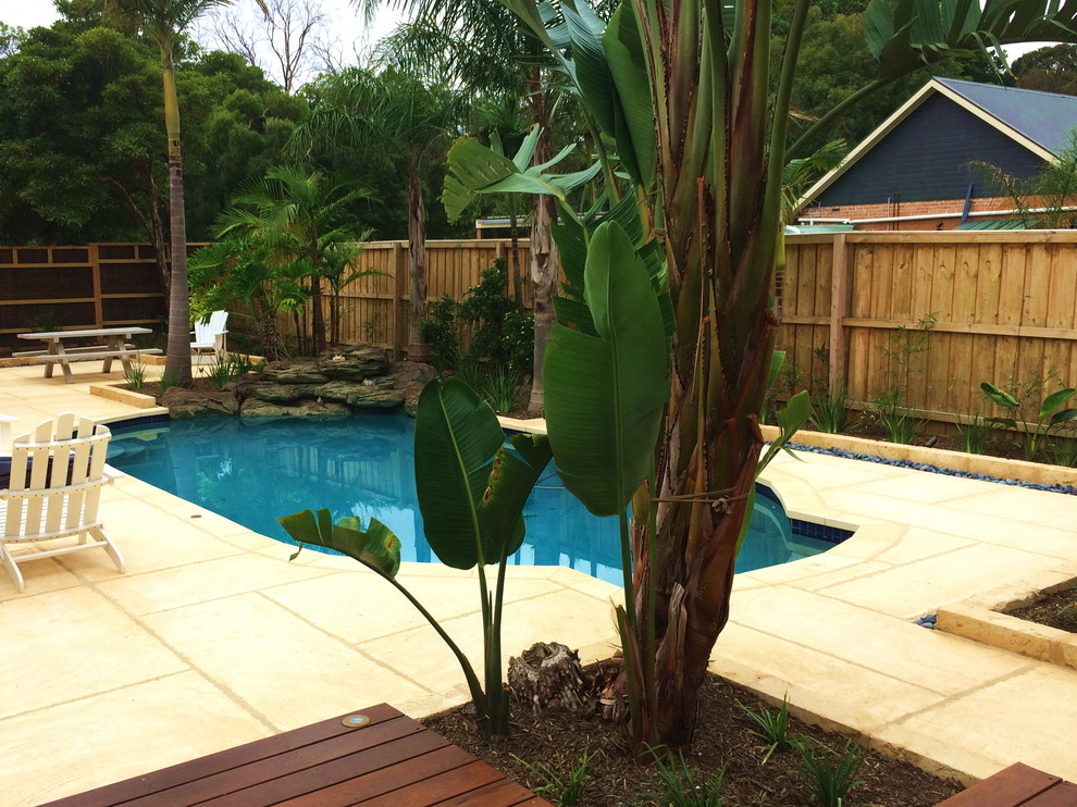 Photo of a mid-sized tropical courtyard pool in Melbourne with decking.